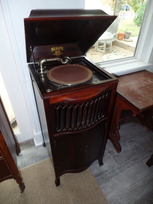 "Sonora" Vintage Record Player. Beautiful dark wood Cabinet with Locking Double Doors to bottom portion of the cabinet. Located in the bottom are many vintage long play albums. Crank handle is located on the right side of the cabinet.