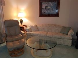 Faux leather swivel chair with ottoman
Swan glass top coffee table
Couch - sofa