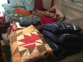 Various quilts, comforters, blankets, and decorative pillows