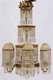 Lot#38, CRYSTAL AND D'ORE BRONZE CHANDELIER, H 40", DIA 26"Having four tiers d'ore bronze rims, six extending arms with beaded dome shades. Long handing prism, gas converted to electricity. Beaded and long prisms cover each tier. 40" H. x 26" Dia.  Circa 1900.