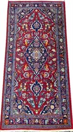 Lot#49, PERSIAN KASHAN WOOL RUG, 1970-80, 5' X 2' 5"Having three floral design borders, two of light blue and one of navy, red ground; diamond shape central floral medallion flanked by two smaller flower medallions.