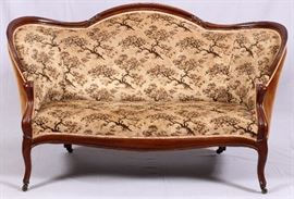 Lot#104, VICTORIAN WALNUT SETTEE, CIRCA 1870, H 37" L 64" D 32"Having a newer, tree pattern upholstery, with carved arched back rest frame turning at the sides to form the armrests, contoured frame across the front. Cabriole legs on casters. Brown velvet across the back and sides.