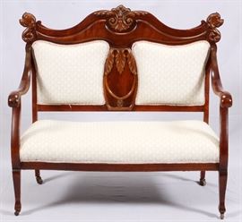 Lot#106, UPHOLSTERED MAHOGANY SETTEE, CIRCA 1900, H 44", W 47"Having a carved acanthus leaf motif at the crest and sides of the back splat, with open arms.  On castors.  Measures H.44" x 47" x 25".