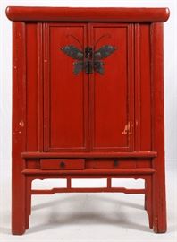 Lot#110, CHINESE CARVED WOOD CABINET, H 71", L 47", D 21"Chinese carved wood cabinet painted red and having a brass butterfly form escutcheon on the front cabinet doors which open to two shelves with integral drawers. Two narrow drawers below cabinet doors. Square legs with stretchers.