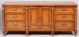 Lot#359, CENTURY EMPIRE MAPLE TRIPLE DRESSER, H 32", W 72", L 19"Four ladies masks on the tops of the front vertical supports.  Nine drawers, including three paneled drawers with bunting style brass pulls flanking two cabinet doors opening to three open drawers.  Brass caps on the ends of the feet.