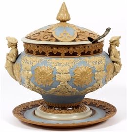 Lot#1013, VILLEROY AND BOCH METTLACH POTTERY TUREEN AND TRAY H 14" DIA 14"#418. Under plate 13 1/2"dia ,double figural handles, raised relief vintage design. Cover with spear finial. Also silver plate ladle.