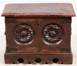 Lot#1064, CONTINENTAL HAND CARVED WOOD CHEST, POSS. 18TH C., H 21", W 14", L 27"A hand-carved oak chest or box. Possibly Flemish, possibly 18th century. The rectangular hinged-top opening to void interior, the double carved front with floral medallions, above a scalloped pedestal base with hand-wrought iron strap work and hinges, with fitted iron carrying handles to sides, raised on a shaped pedestal base.