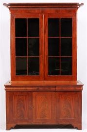 Lot#1113, AMERICAN MAHOGANY BOOKCASE/DISPLAY CABINET, H 96", W 60 1/4", D 23 3/4"An American mahogany display cabinet. 19th century. Probably adapted from a larger bookcase. The molded cornice above a pair of glazed paneled doors enclosing adjustable shelves, surmounting three paneled doors, raised on ogee bracket feet.