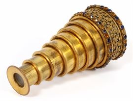Lot#1152, A CHARLES X GILT METAL TRAVELING TELESCOPE; 19TH CENTURY, L 3 3/4"A Charles X gilt metal telescope with an applied gilt floral design. Early 19th century. Set with blue and yellow semi-precious stones. Dia. of collar 1 7/8", length extended 3 3/4".