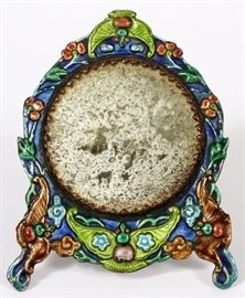 Lot#1481, A CHINESE SILVER AND ENAMEL DRESSING MIRROR, H 5 1/4" the circular glass mirror plate within a shaped silver and polychrome frame having an easel back, the borders with a floral and fauna theme. Height 5 1/4", width 4 1/4".