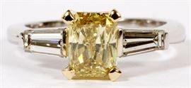 Lot#2045, 1.37CT FANCY YELLOW DIAMOND AND 14KT WHITE GOLD ENGAGEMENT RING, GIA, SIZE 6.25. Having a center 1.37ct natural fancy brown-yellow radiant cut diamond, flanked by .75ct side baguettes.  The center diamond has an Si-1 clarity, the side baguettes have an H color and VS-2 clarity.  GIA report #2175348603.  Weighs 4.1 grams.