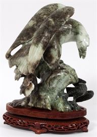 Lot#2172, CARVED SERPENTINE EAGLE SCULPTURE H 9" (W/O STAND), EAGLE. Depicts a carved serpentine eagle on a rocky perch mounted on a carved wood footed stand with pierced design.  With wood stand,