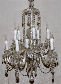 Lot#2231, ITALIAN TEN-LIGHT CRYSTAL CHANDELIER, CIRCA 1940, H 42", DIA 29" Cut crystal canopy and hourglass-shaped light elements.  Spherical, faceted orb at base.  Candle-style lights with cut-crystal bobeches.  Twenty faceted 3" long pendants, faceted beaded swags link the ten light elements.