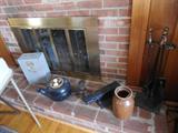 Take a look on the fireplace hearth....crock, metal box, old iron items, small black TV stand, etc..Fireplace accessories....