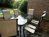 Lots of outdoor patio furniture, charis, swings, tables, grill, yard artwork...