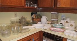 Over-full kitchen with many new and new in box items. All basic items including: solid white dish set, several pot and pan sets, drinkware, utensils old and new, knives and knive sets (Cutco), storage containers, entertaining items, cooking and baking.