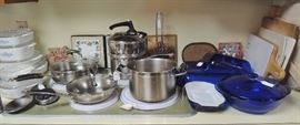 Over-full kitchen with many new and new in box items. All basic items including: solid white dish set, several pot and pan sets, drinkware, utensils old and new, knives and knive sets (Cutco), storage containers, entertaining items, cooking and baking.