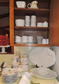 Over-full kitchen with many new and new in box items. All basic items including: solid white dish set, several pot and pan sets, drinkware, utensils old and new, knives and knive sets (Cutco), storage containers, entertaining items, cooking and baking.