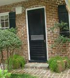 PLANTS IN PLANTERS ON EITHER SIDE OF CARRIAGE HOUSE DOORS