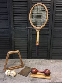 Lot of industrial looking, vintage sports items including 2 baseballs, a vintage tennis racket with cover, on set of vintage wooden dumbbells mounted to a wooden board for display with a cool antique industrial stand you can do almost anything with!