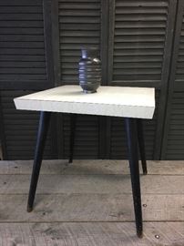 Mid century modern, Eames era, side table with grayish weathered wood type Formica top and Black charcoal colored wooden hairpin style legs. Measures approx 21 x 21 inches.