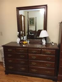 Two bedrooms of traditional cherry furniture--dressers with mirrors, chests, nightstands and beds. 