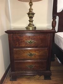 Two bedrooms of traditional cherry furniture--dressers with mirrors, chests, nightstands and beds. 