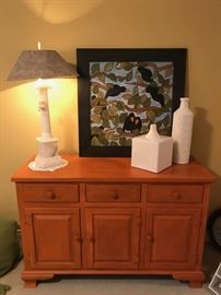 Shelly Neitering-Engel artwork of crows setting on orange painted Ethan Allen maple chest. White pottery accent pieces