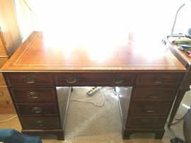 Baker leather top Georgian style mahogany desk w/gold gilt leather inset and brass fixtures. Double pedestal. 48"L x 29"W x 29"H