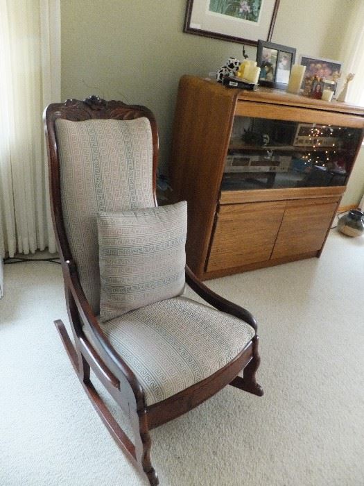 ANTIQUE ROCKING CHAIR AND CABINET THAT HOLDS A STERIO SET