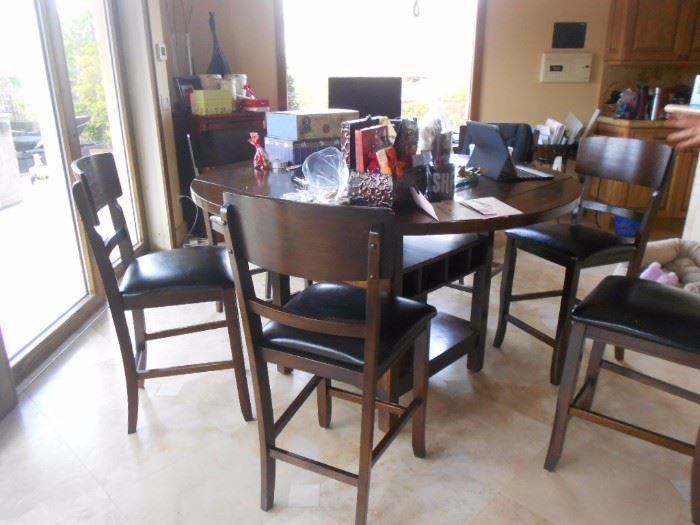 Medium height round wood table, 8 chairs.  Table is round with built in Lazy Susan, but has sliders under table top that can allow table to top and become square.  
