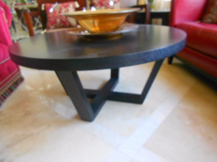 Coffee table, four leather circular low chairs that surround it, and two end tables.