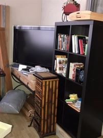 LARGE FLATSCREEN, IKEA BLACK BOOKCASE, BOOKS, TABLE WITH WROUGHT IRON BOTTOM