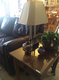 Three-cushioned leather sofa; end table; one of many lamps