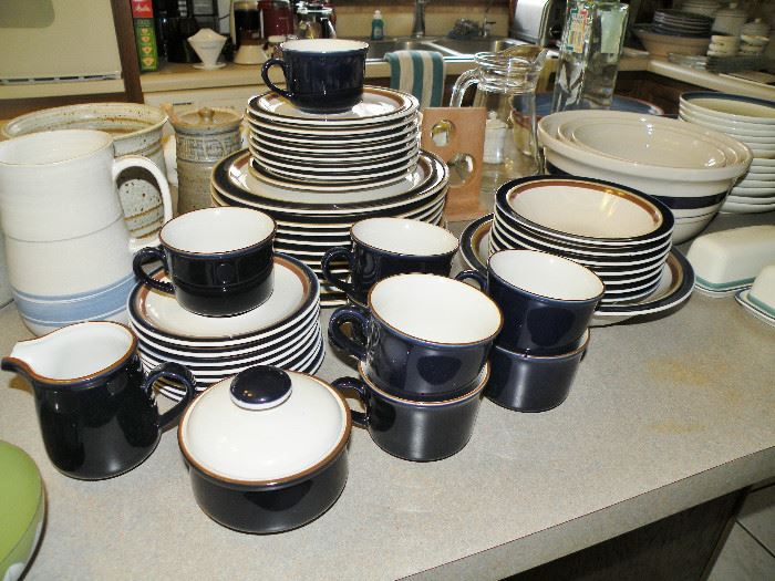 Many stoneware dinnerware sets and serving pieces.