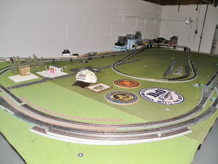 HO train set layout. It looks like the layout was never finished being built; all the cars and buildings are still in their boxes, never having been opened.