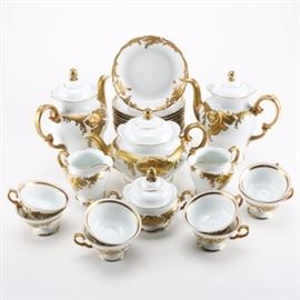 Circa 1950 Polish Porcelain Dinnerware: A selection of vintage Wawel WAV19 pattern and Walbrzych marked Polish porcelain dinnerware. The selection features white porcelain decorated with ornate applied gold tone scrolls and black accents. The collection features eight teacups, twelve soup bowls, two tea pots, one coffee pot, two creamers, and one sugar bowl. Pieces are marked “Wawel, Made in Poland, Recznie, Malowane” or " Walbrzych, Made in Poland" to the underside.