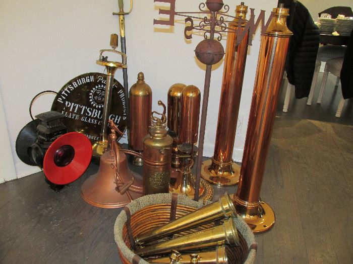 Brass train whistles, firehose nozzles, antique saber and train signal.