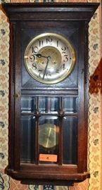 Lot 4: Antique dark oak clock with beveled glass door and key, unmarked; preview for working condition; 28"h x 15"w x 5"d, with applied carving

