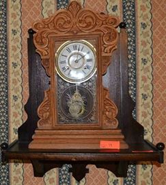 Lot 13: Antique oak Gingerbread mantle clock with key, unmarked, includes wall mounted shelf; preview for working condition.  At time of inventory clock in running condition
