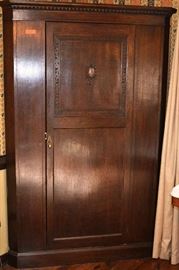 Lot 27: Antique oak corner wardrobe with pull-out brass rod and inside beveled full-length mirror, comes with casters; 77"h x 51"w x 24"d
