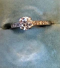 Lot 47: Platinum engagement ring center European cut diamond measuring 5.4MM x 3.4MM and weighing approx. .60 carats.  Diamond is white in color and "H" and "VS" clarity.  Center diamond as a channel on each side containing 5 single cut diamonds, weighing .02 carats each.  Ring size 5
