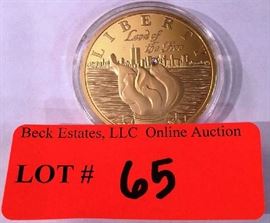 Lot 65: American Mint Medal - Liberty Land of the Free with Swarovski crystal chip.  "Statue of Liberty" on reverse.  Gold plated over copper.  Encased in plastic.
