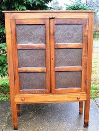 Lot 103: Antique pie safe, poplar, with 6 punched tins on double doors.  Fitted with wooden shelves on interior.  Paneled sides and straight legs with bottom elongated drawer.  Top contains old tin/metal patch.  14 1/2"d x 41"w x 60"h
