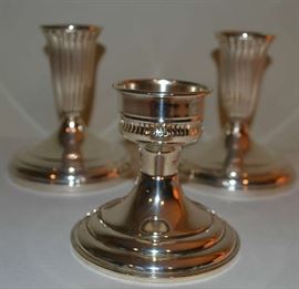 Lot 111: 3 Sterling silver weighted candlesticks,  1 pair of Revere Silver Co. marked #110, minor pin point dents, 1 single candlestick marked Preisner #899, pair measures 4 1/2"h, single measures 3 1/2"h.  (13)
