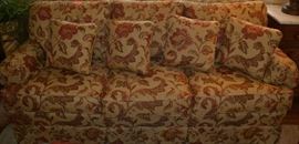 Lot 407: Three cushion sofa by Pope's Signature Gallery with three cushion back and throw pillows; 34"h x 80"w x 34"d, upholstered in taupe and rose floral fabric, matches lot 408
