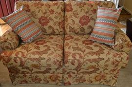 Lot 408: Two cushion love seat by Pope's Signature Gallery (34"h x 54"w x 34"d), includes throw pillows, upholstered in taupe and rose floral fabric, matches lot 407
