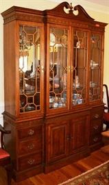 Lot 420: Chippendale style China cabinet with glass doors with wood fretwork, glass shelves, and cupboard section below, topped by broken arch pediment; 84"h x 64"w x 16"d, by Pennsylvania House
