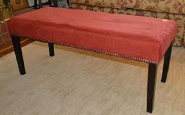 Lot 431: Upholstered bench (18"h x 42"w x 16"d), red new suede type upholstery with straight legs and apron accented in upholstery studs
