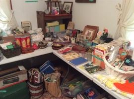 Vintage stool in corner, pictures, planners, calendars, phone books, knitting & crochet needles in potato chip rounds, baskets filled with items on floor, cheesecloth material pieces and more .....